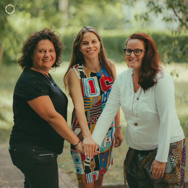 Three women put hands together